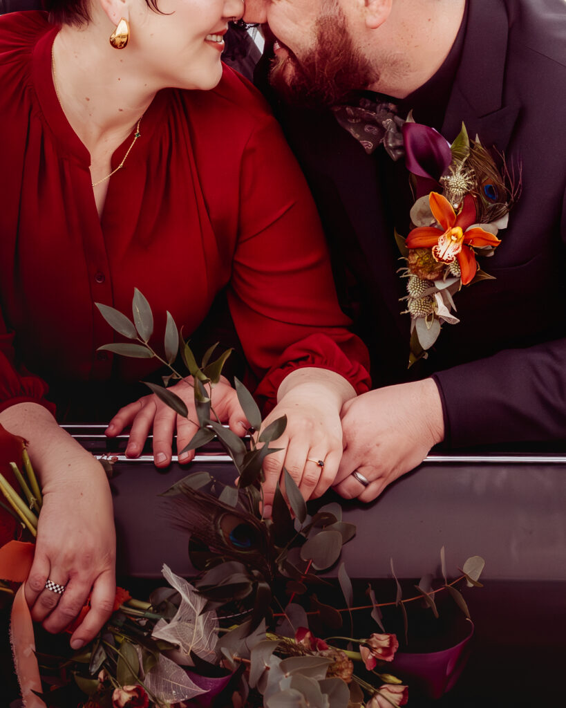 Couple face to face with a floral lapel piece on the male's jacket. 