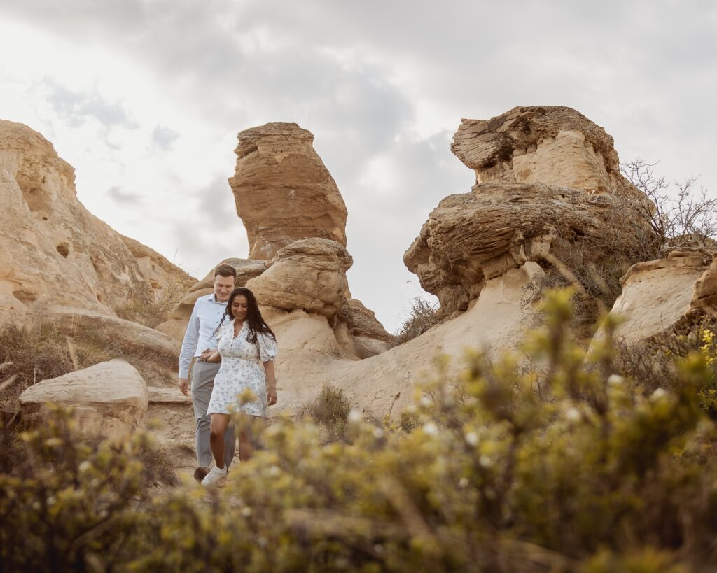 Couple walking through the hoodoos in Writing-on-Stone Provincial Park.