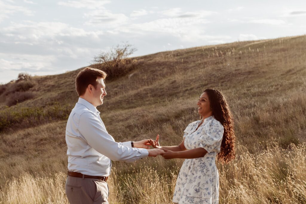 Couple spinning and dancing in the grass.